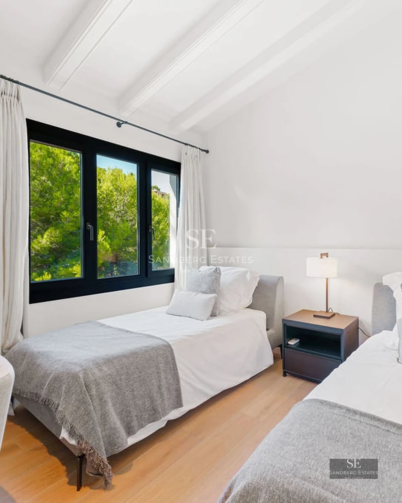 View from a modern balcony with glass railing, light tile flooring, and panoramic sea views. Minimalist architecture.