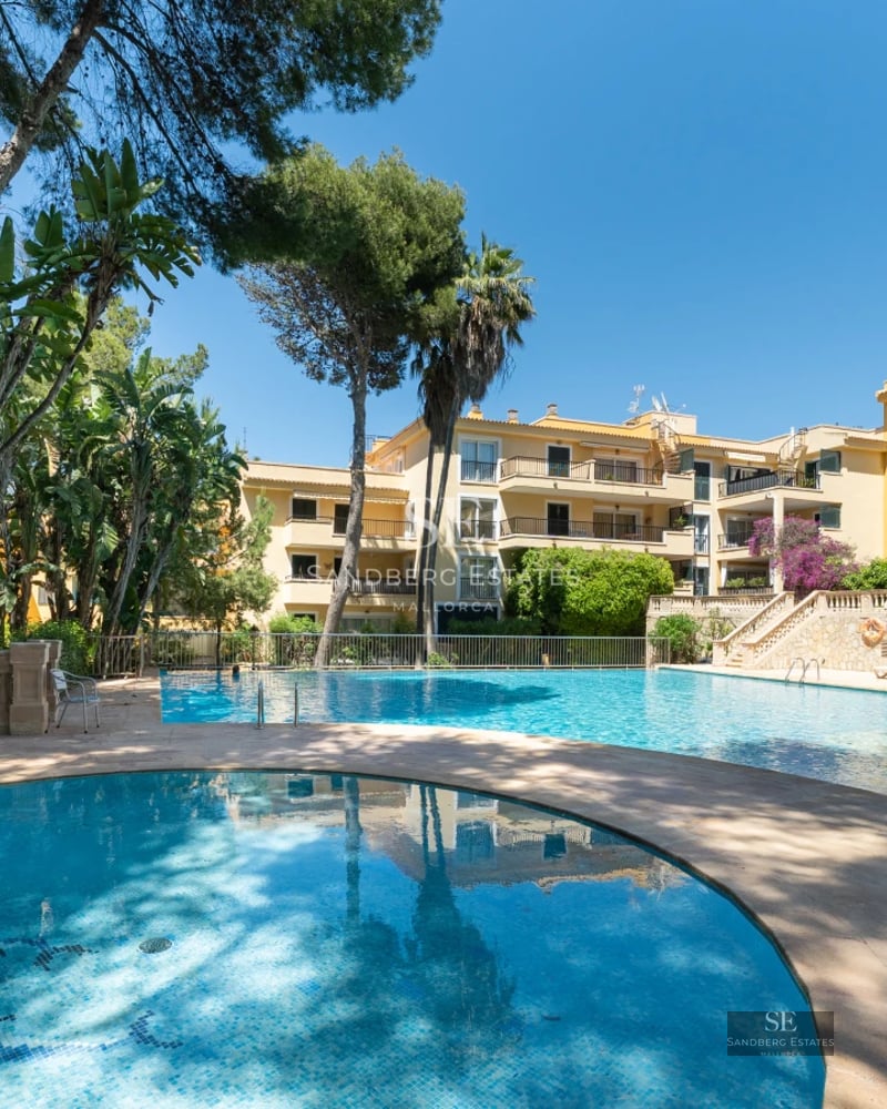 Exterior view of modern villa with reflecting pool, expansive garden, and minimalist architecture. Soft ambient lighting.