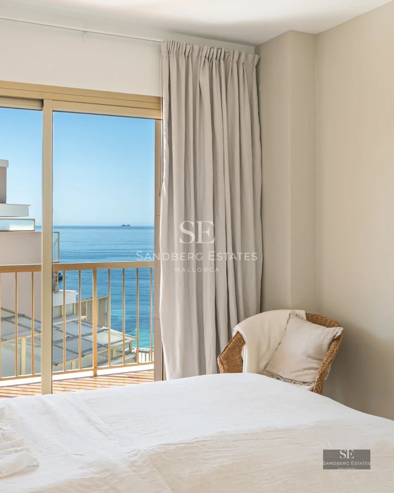 Spacious living room with floor-to-ceiling windows, reflecting pool, light wood floors, and minimalist design. Garden view.