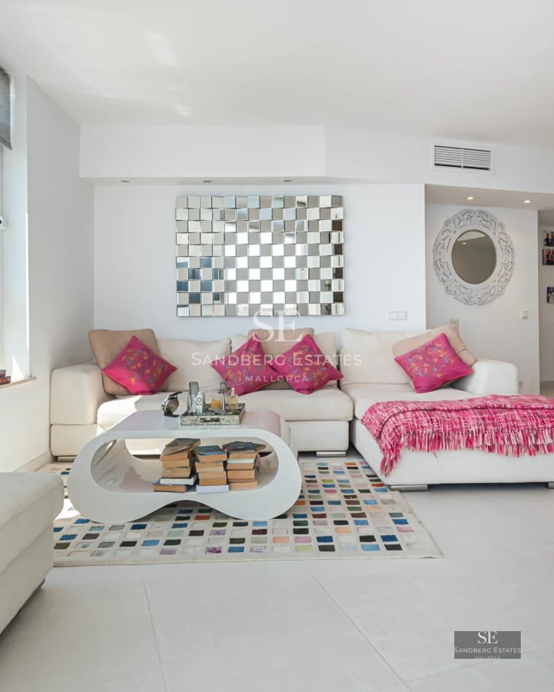 Aerial view of a modern residence featuring an infinity pool, expansive terraces, and lush surrounding greenery.