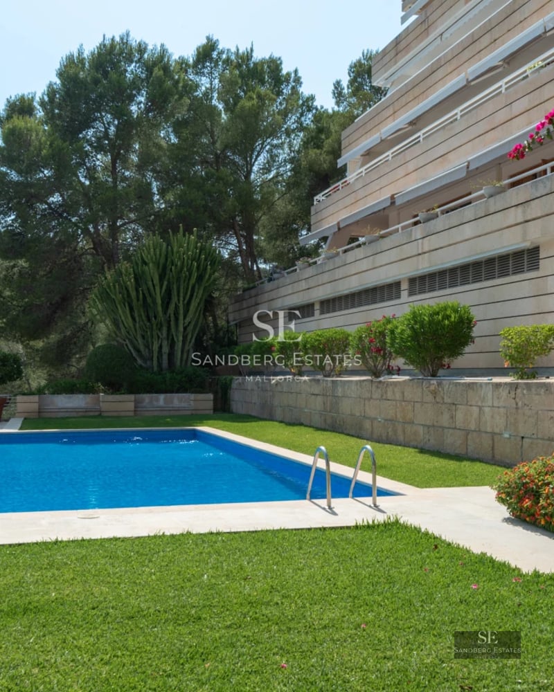 Exterior view of a modern villa with infinity pool, lush gardens, and spacious terraces. Elegant architectural design.