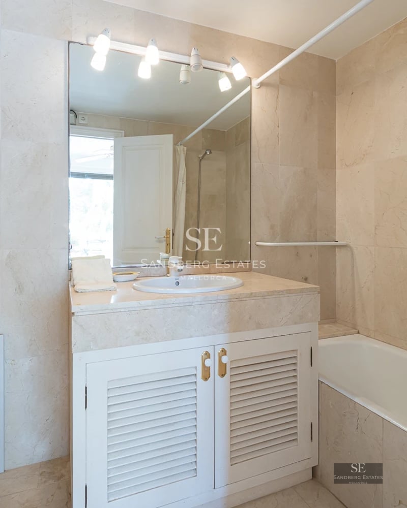 Spacious balcony with sea view, glass railing, wooden floor, and modern furniture. Minimalist and bright design.