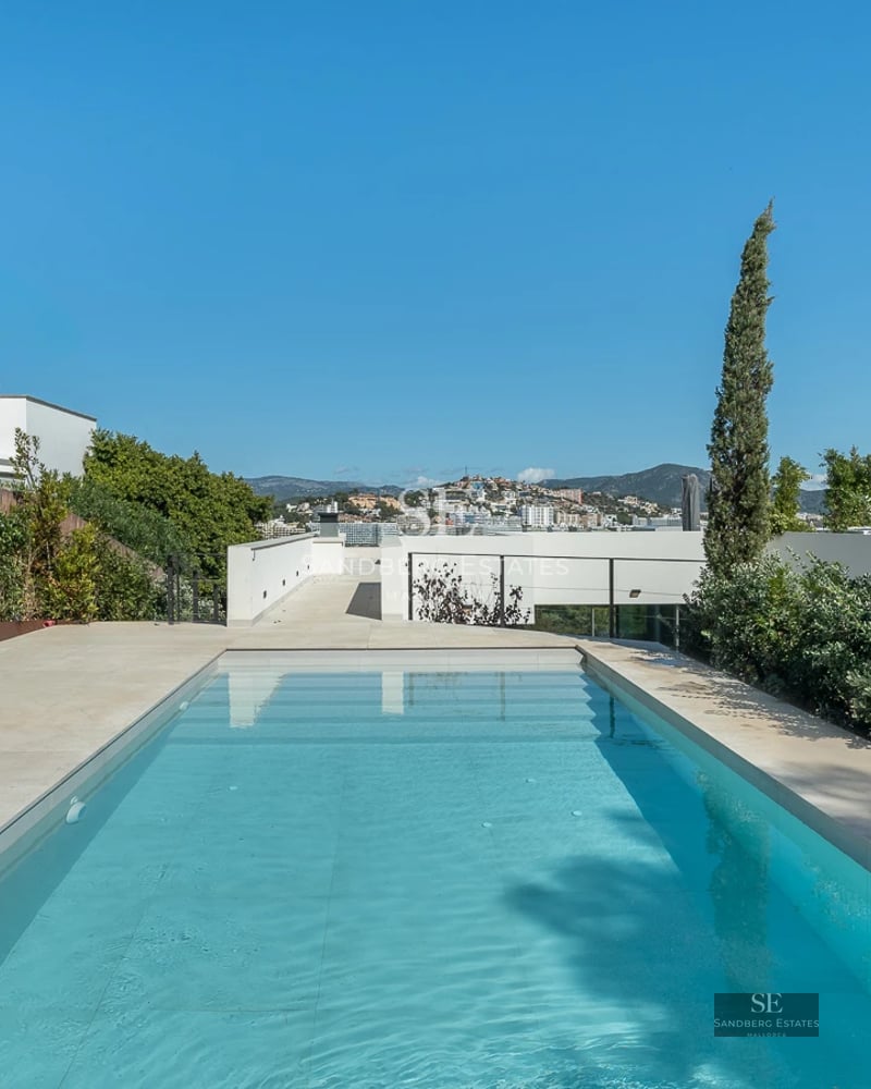 Modern villa featuring an infinity pool, large windows, and minimalist architecture. Warm lighting and designer furniture.