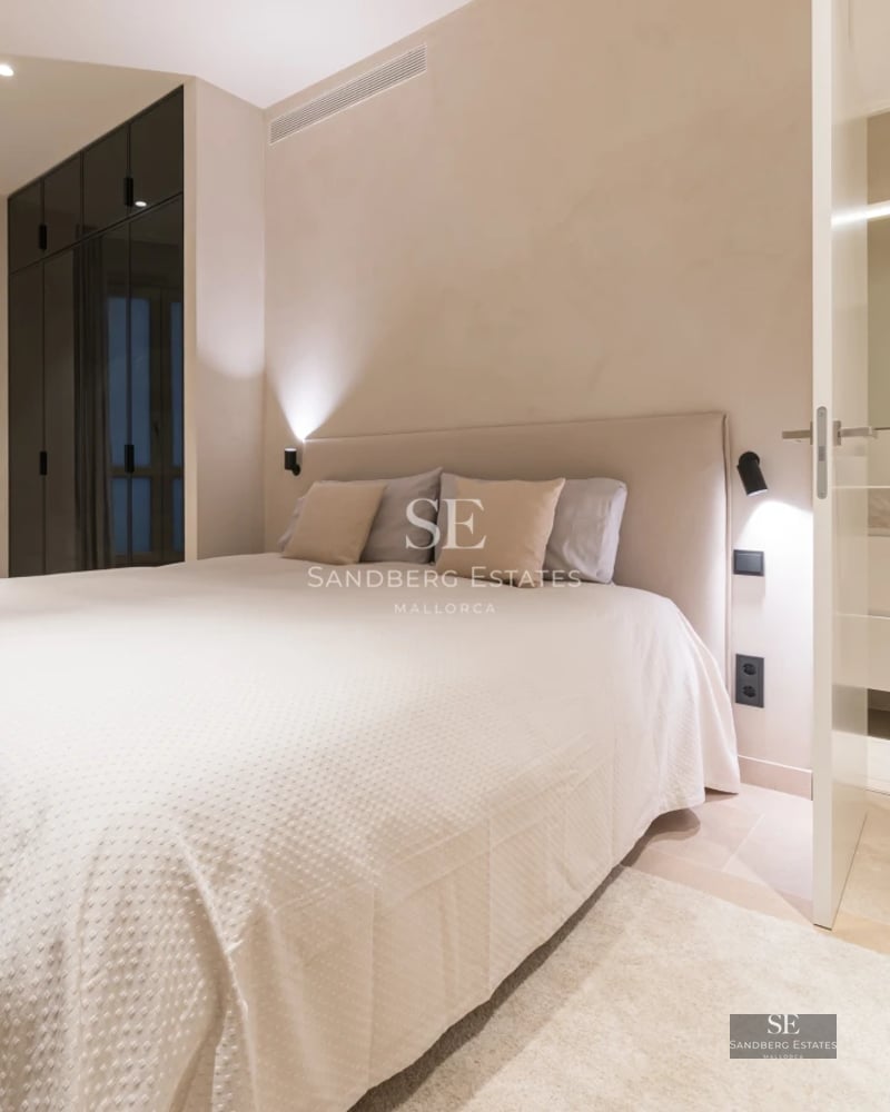 Spacious living room with large windows, light wood flooring, and modern furniture. Natural lighting and panoramic views.