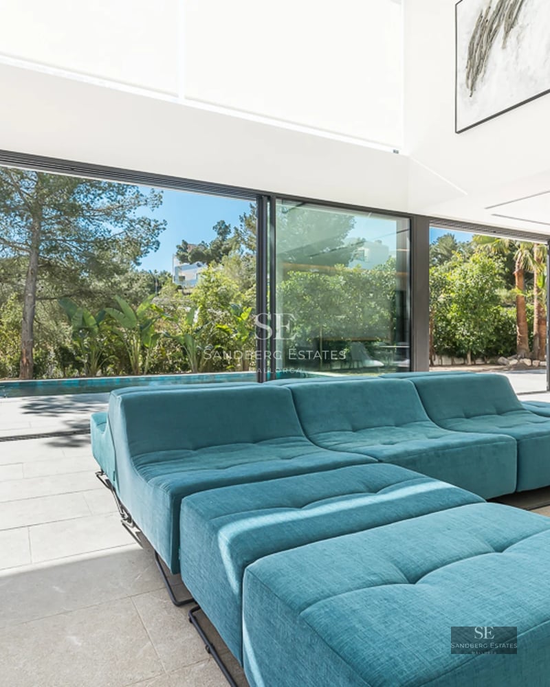 Vue aérienne d'une villa moderne avec piscine à débordement, jardin paysager, terrasses spacieuses et architecture minimaliste. Détails de l'aménagement paysager et du design extérieur.