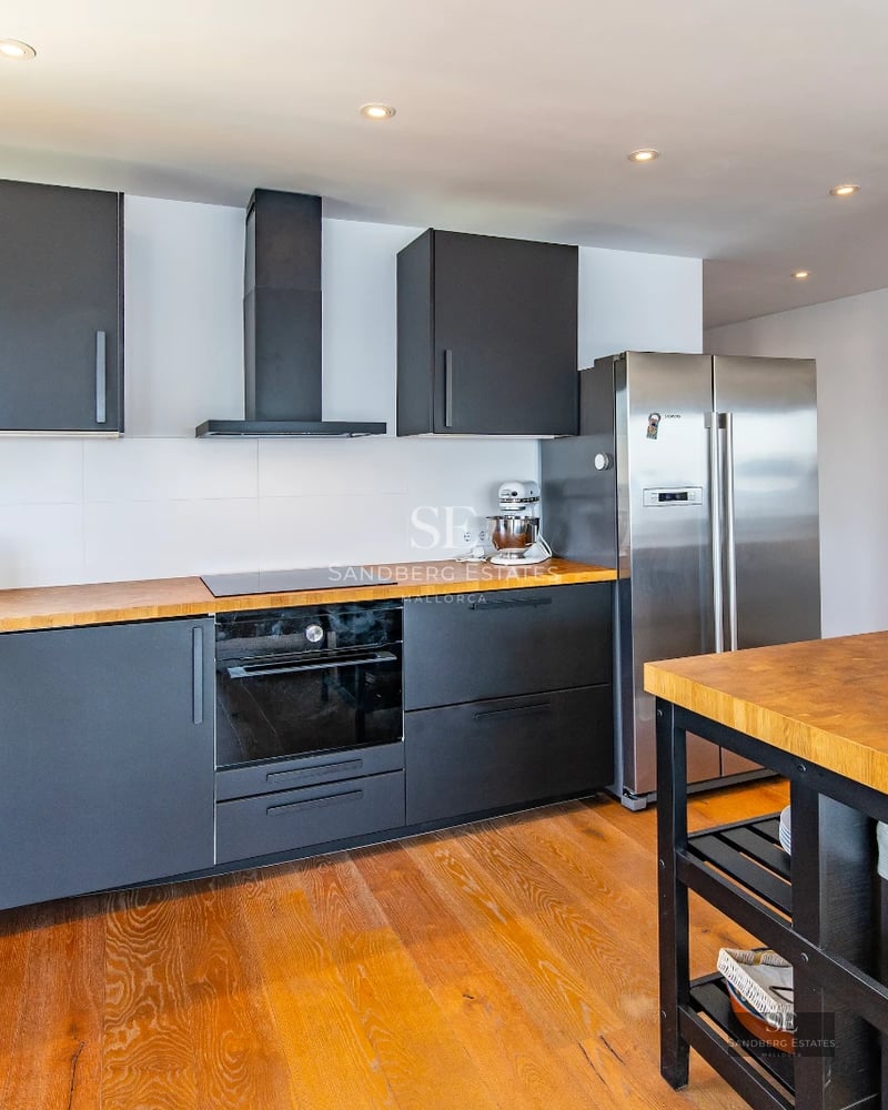 Bright living room with large windows, light wood floor, modern fireplace, and designer furniture. Panoramic outdoor views.