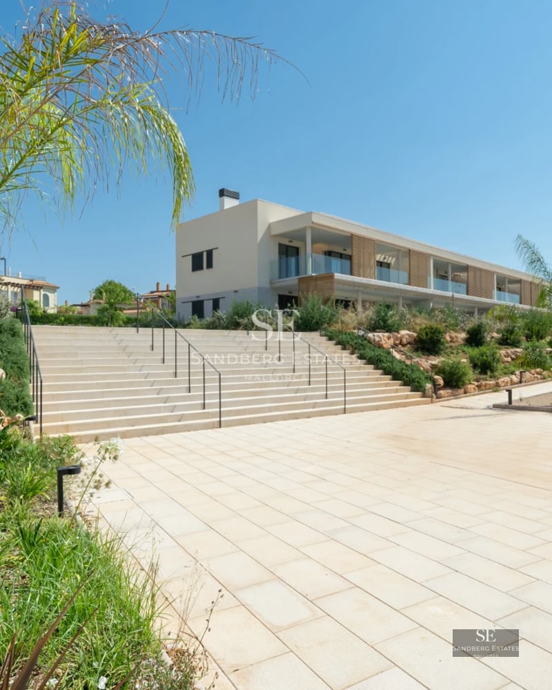 Exterior view of a modern villa with a pool, large windows, and sleek design. Minimalist architecture and lush gardens.