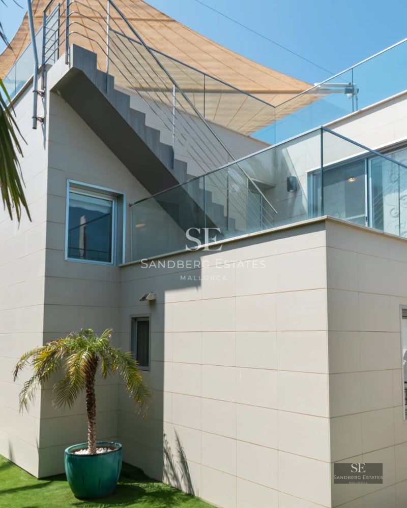 View of minimalist pool surrounded by terrace with sun loungers. Modern design with lush vegetation. Soft ambient lighting.