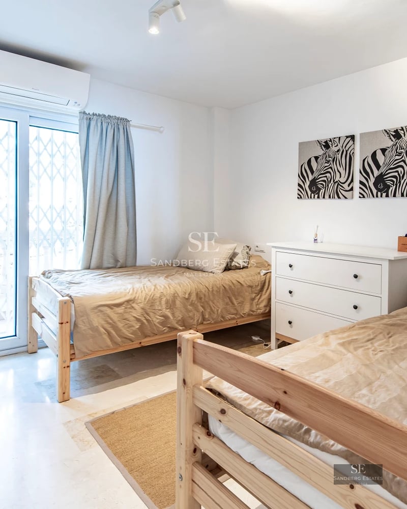 Spacious living room with panoramic windows, light wood flooring, modern fireplace, and minimalist furniture. Abundant natural lighting.