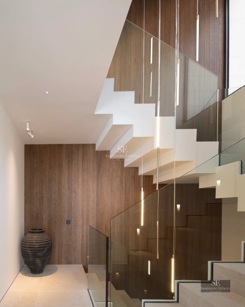 Exterior view of a modern villa featuring a pool, lush garden, and expansive terraces. Minimalist architecture and abundant natural light.