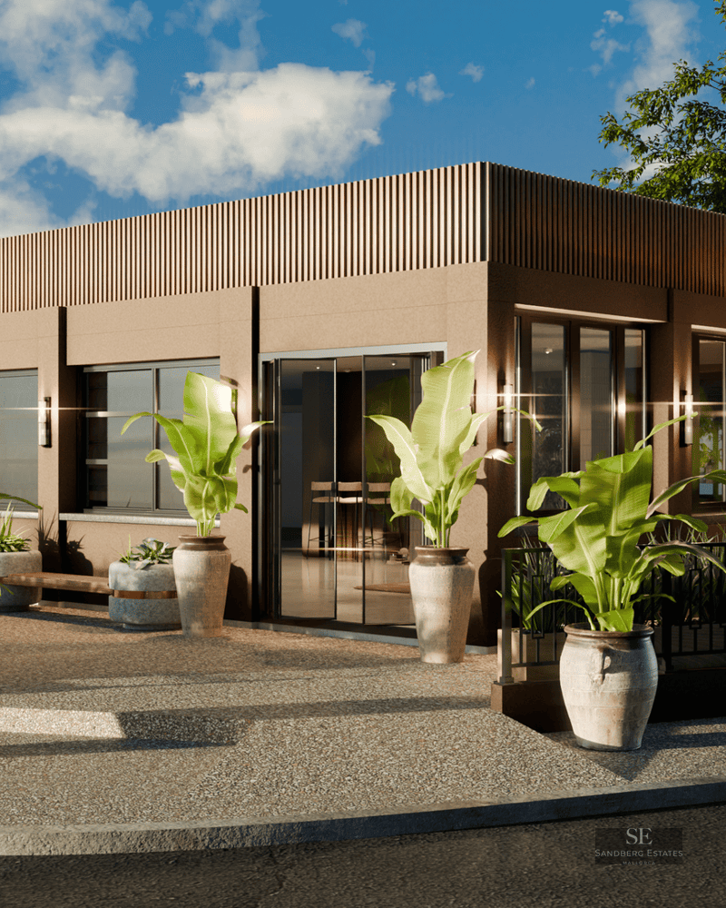 Modern building exterior featuring large potted tropical plants and wooden slat detailing under a bright blue sky.