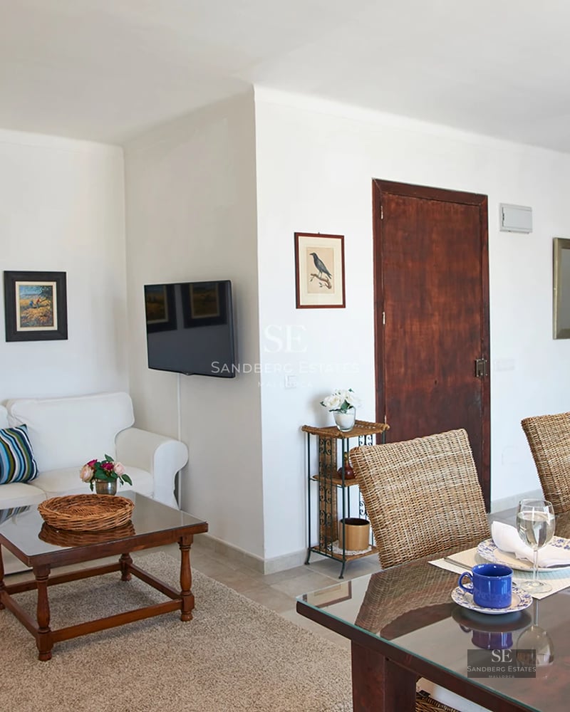 Spacious balcony with sea view. Modern outdoor furniture, glass railing, and tiled floor. Soft lighting and relaxing atmosphere.