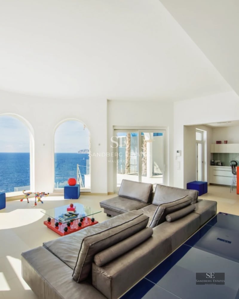 Spacious balcony with panoramic sea views. Modern design, glass railing, stylish outdoor furniture. Ambient lighting.