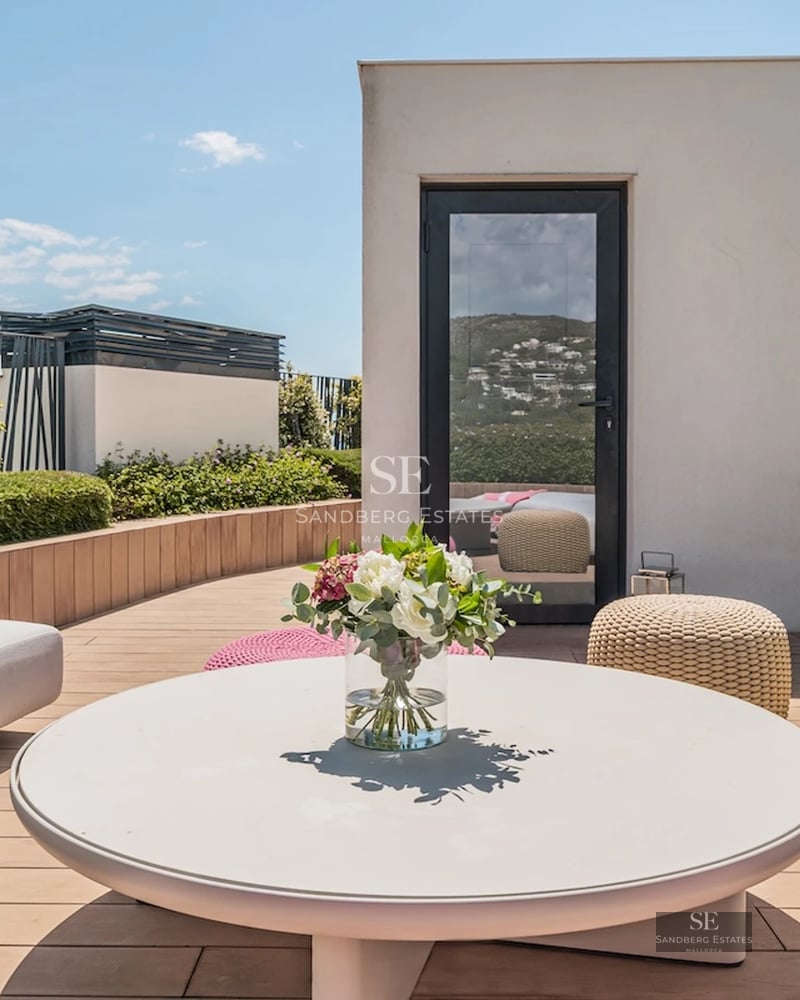 Spacious living room with panoramic windows, modern fireplace, wooden floors and elegant furniture. Panoramic outdoor views.