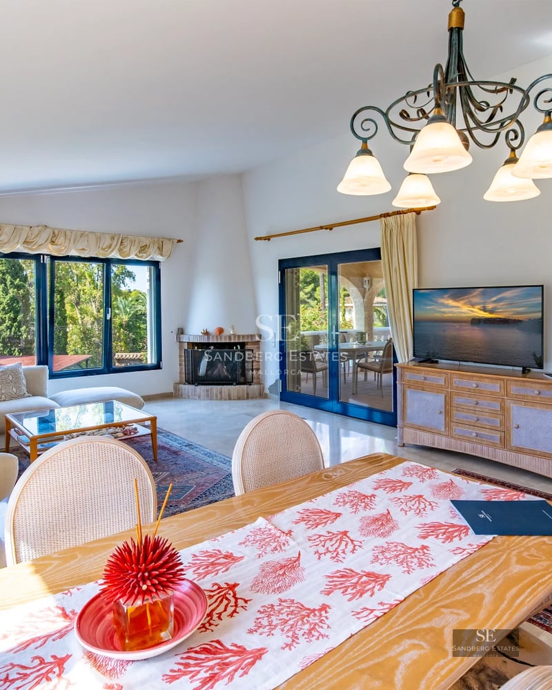 View of a luxurious house with an infinity pool, lush garden, and modern architecture with large windows.