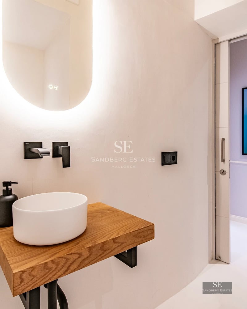 Spacious living room with floor-to-ceiling windows overlooking the sea. Modern interior with stylish furniture and natural light. Beige sofa, light rug.