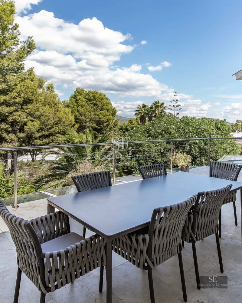 View of a luxury villa featuring an infinity pool, terrace with modern furniture, and lush greenery. Sleek and contemporary architectural design.