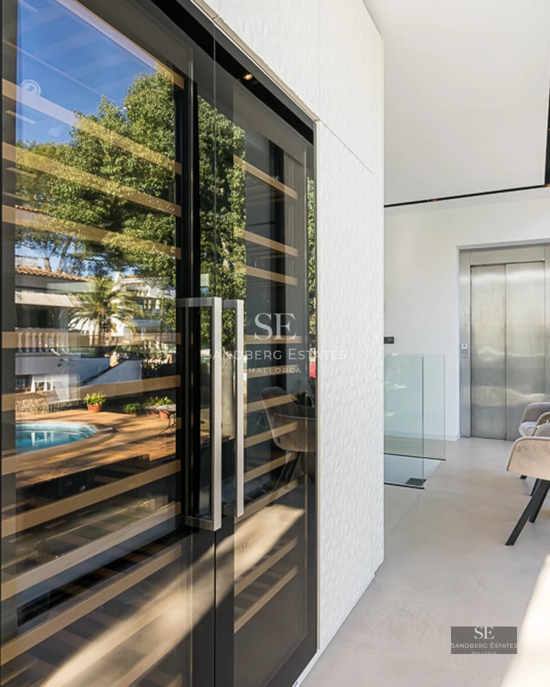 Exterior view of modern villa featuring a pool, lush garden, and large windows. Contemporary architectural design.