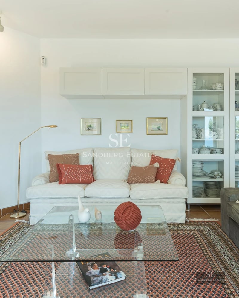 Bright living room with pool access. Large windows, light wood floors, modern design, and unobstructed views.