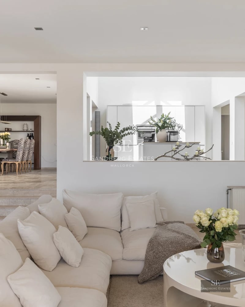 Spacious living room featuring large windows, natural light, modern design, wood flooring and garden and pool views.