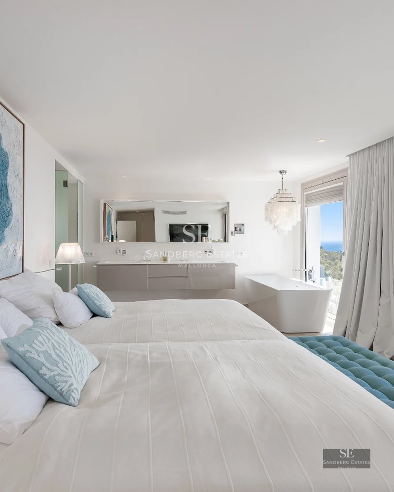 Bright interior with panoramic sea views. Modern design, large windows, light wood floors, and minimalist decor.