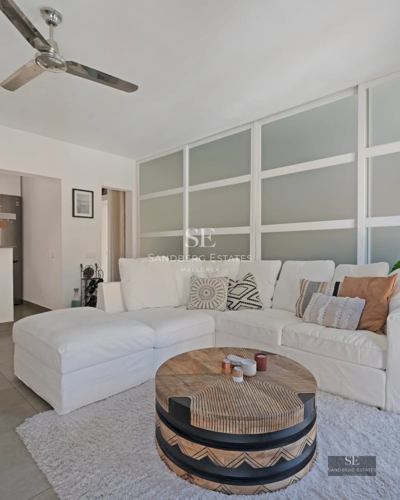 Spacious living room with floor-to-ceiling windows, fireplace, and modern design. Natural light and exterior views. Wood floors, light walls.