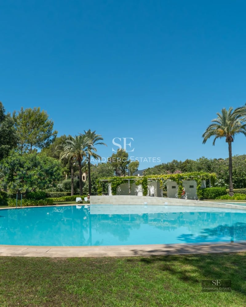 Modern villa with infinity pool, expansive terraces, panoramic windows and minimalist design. Lush vegetation.