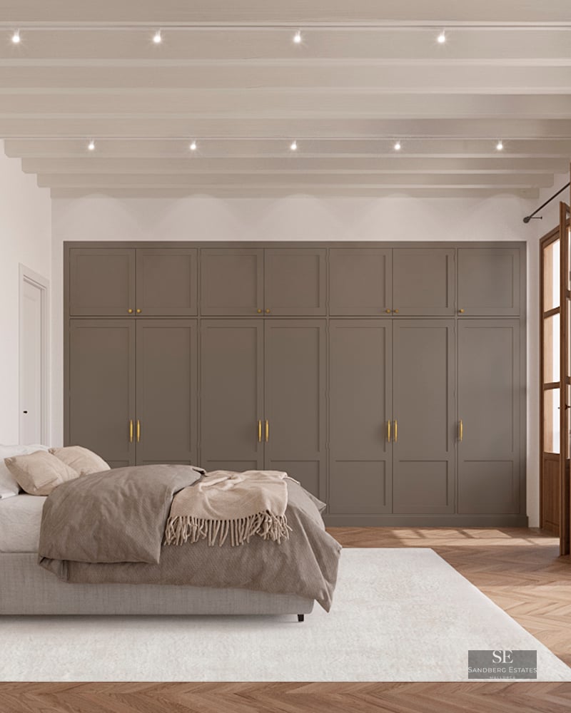 Spacious master bedroom featuring wooden ceiling beams, built-in wardrobes, and herringbone floors with balcony access.