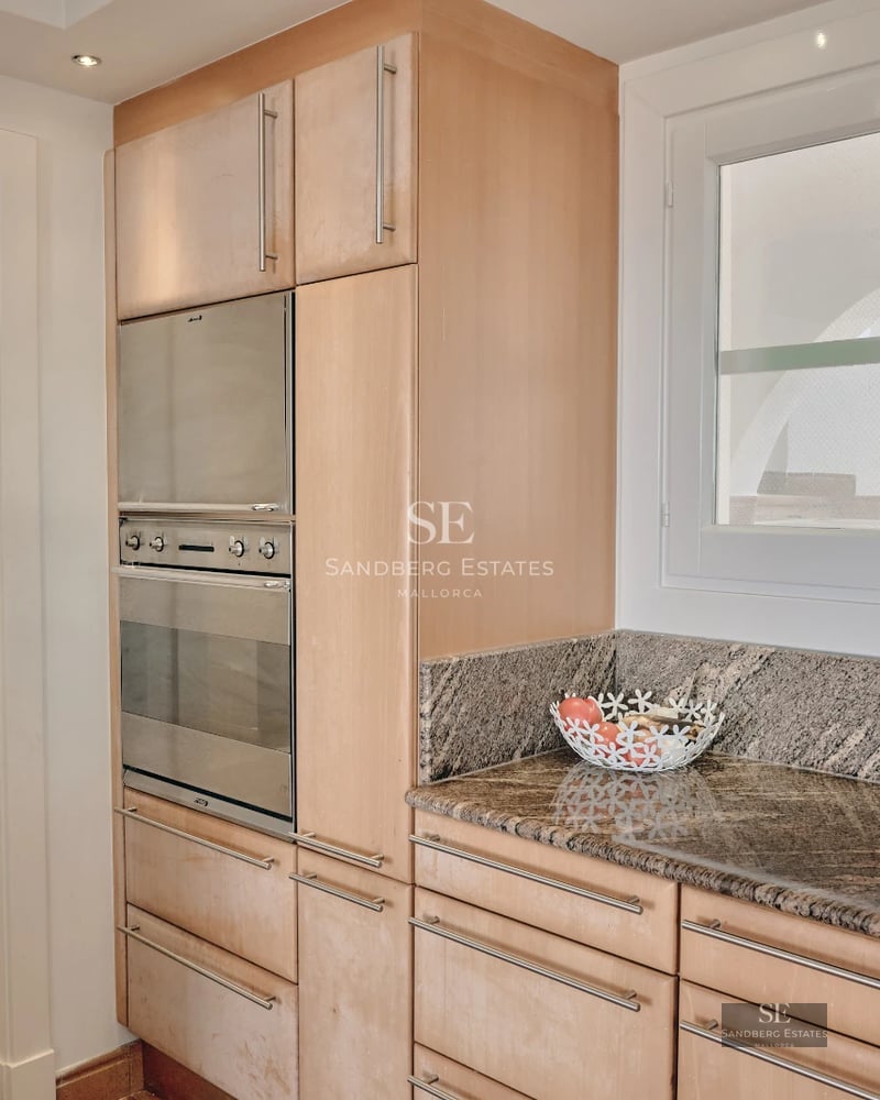 Spacious balcony with sea view. Modern design featuring glass railings and comfortable outdoor furniture.