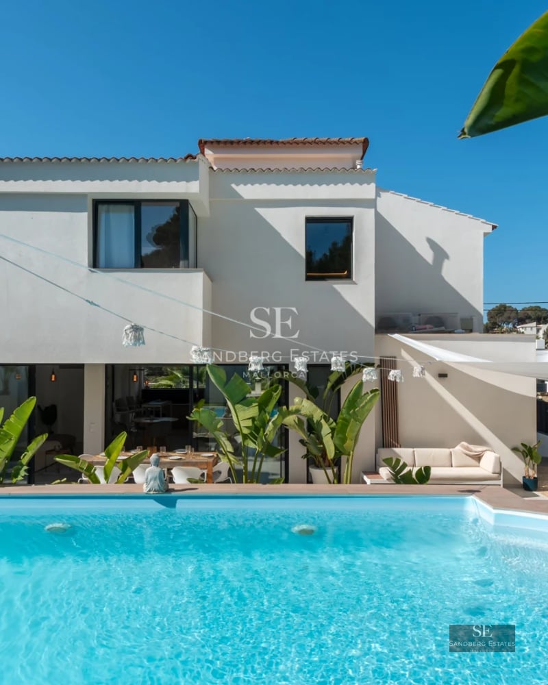 Exterior view of a luxurious modern house with a pool, garden, and large windows. Contemporary architectural design.