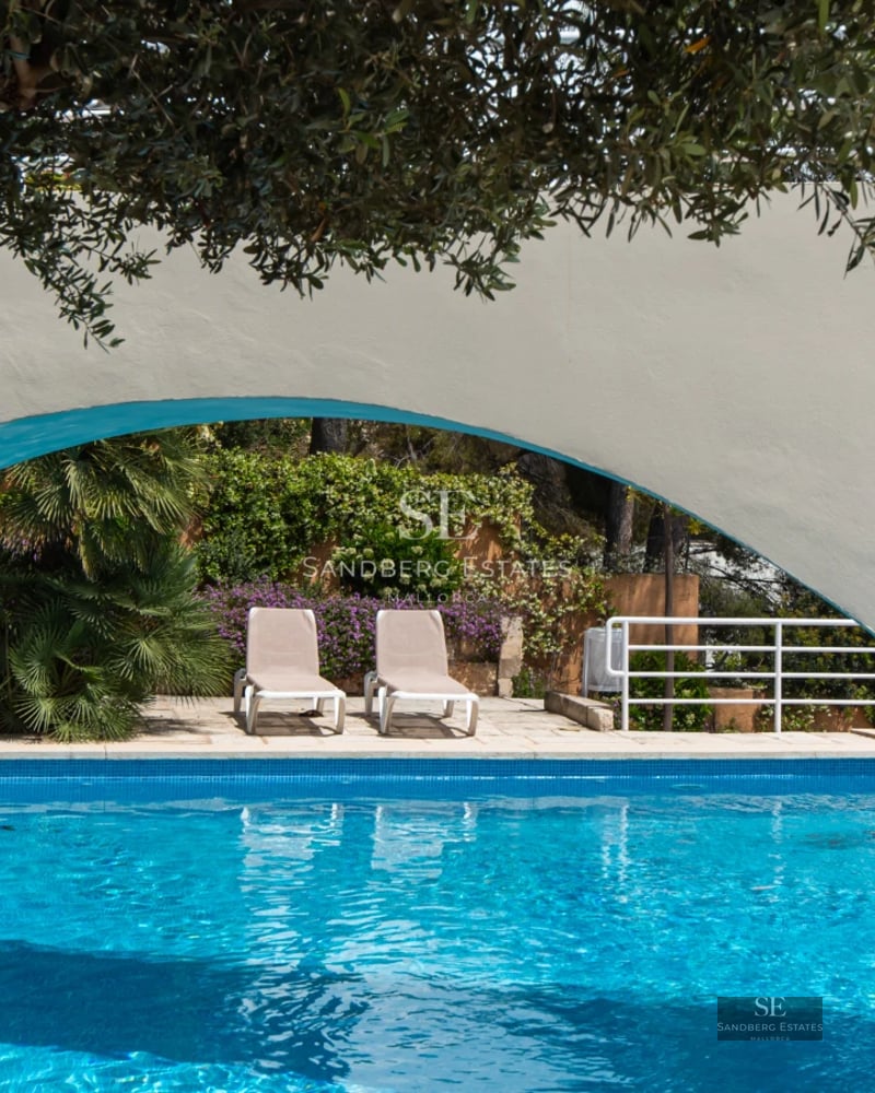 Spacious living room with picture windows, wood floors, fireplace, and designer furniture. Natural light and terrace access with views.