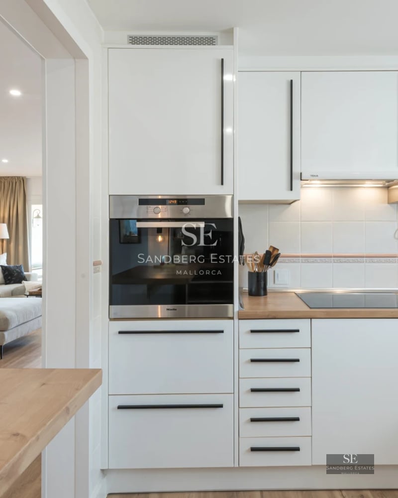 Spacious terrace with designer outdoor furniture, glass railing, and panoramic sea views. Soft lighting and wooden floor.