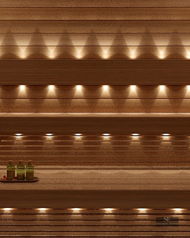 Interior of a wooden sauna with warm integrated lighting, wooden benches, and wellness accessories.