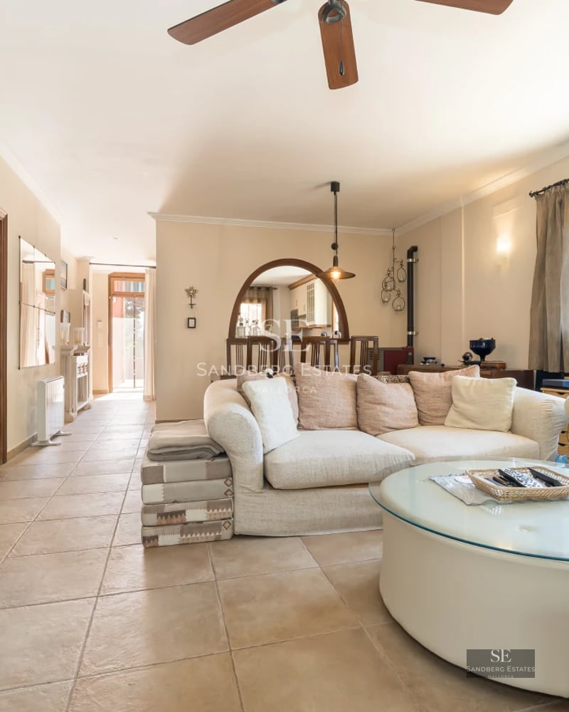 Spacious living room with balcony, light wood floors, white walls, large windows, and sea view. Natural lighting.