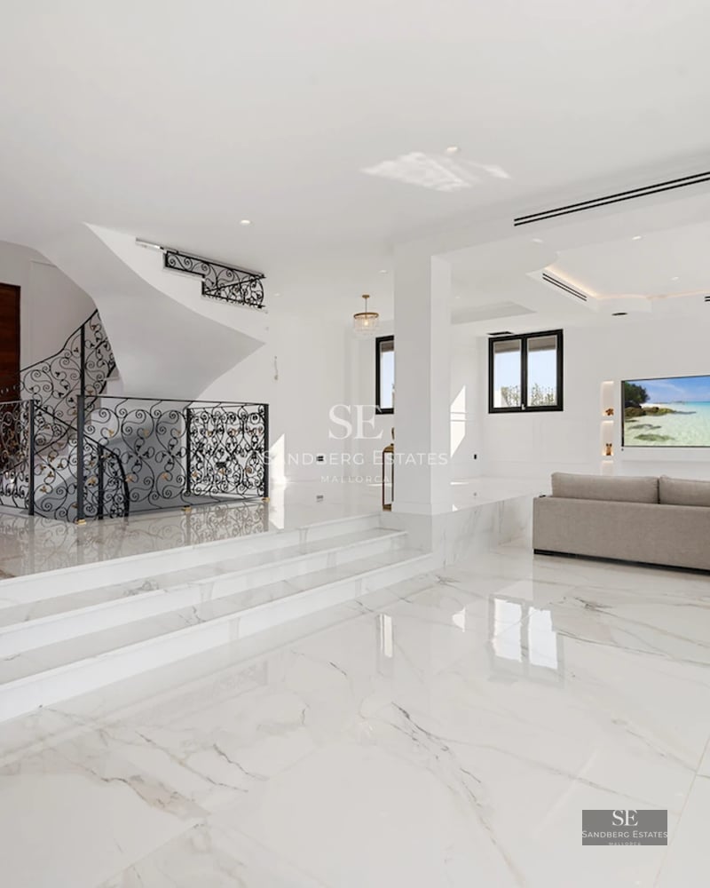 Exterior view of a modern villa with infinity pool, lush gardens, and minimalist architectural design with large window panes.