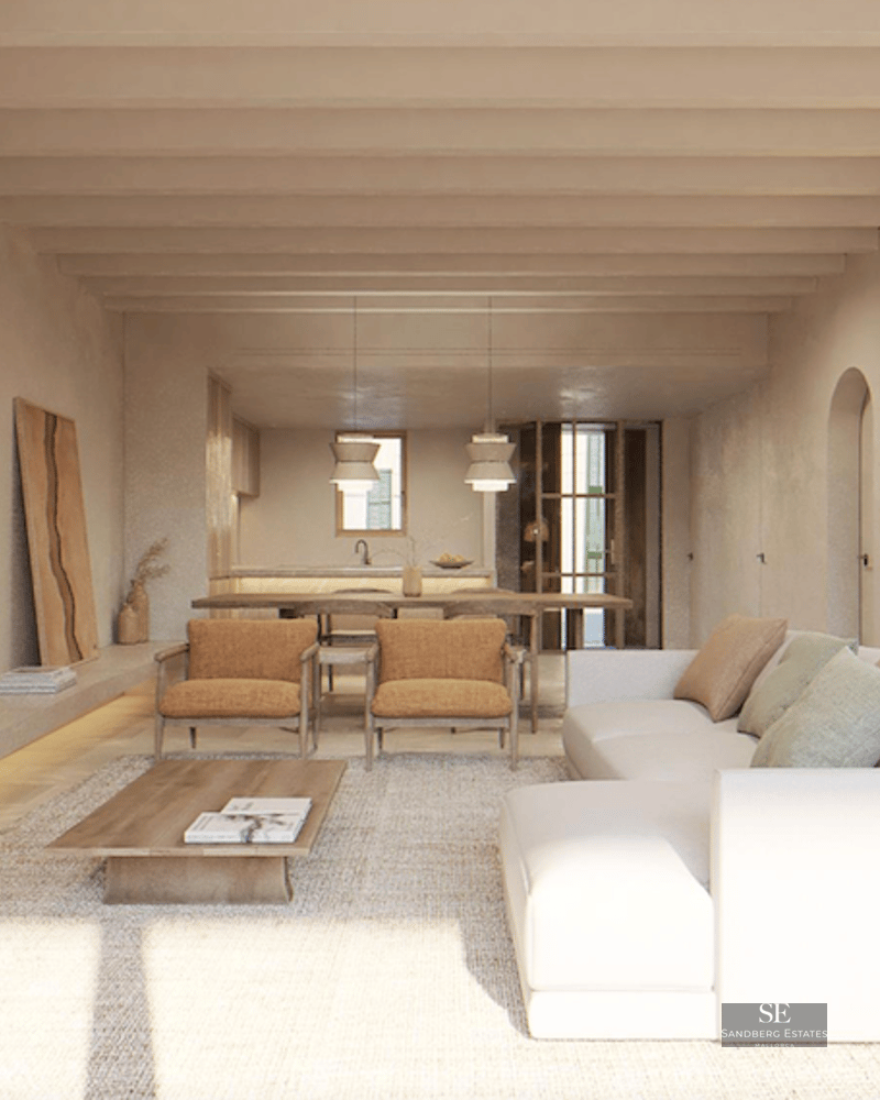 Bright living room with white sofa, wooden ceiling beams, and arched wall niches displaying ceramic pottery.
