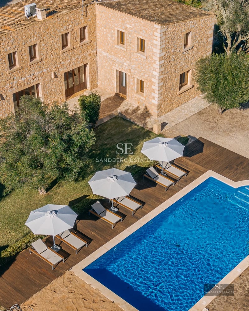 Panoramic view of a modern villa featuring a pool, lush garden, and minimalist architecture. Large windows and a sunny terrace.