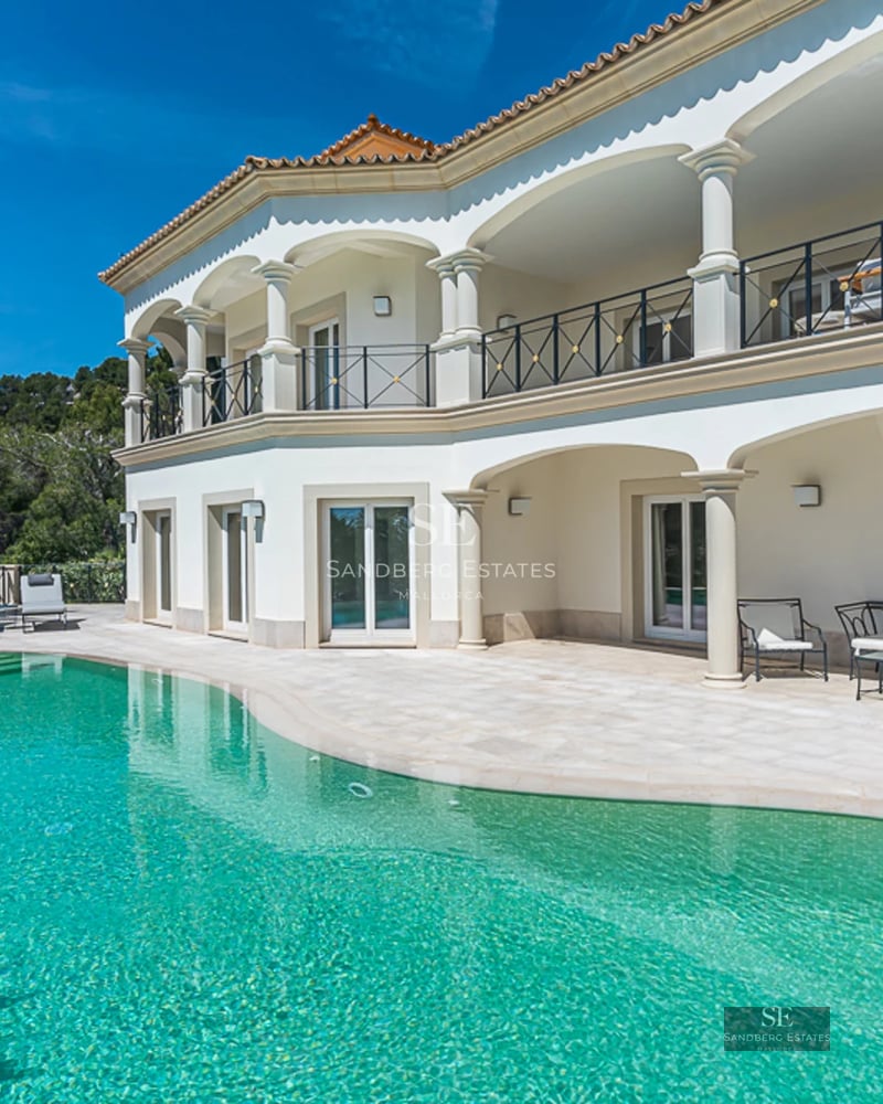 Exterior view of a luxurious apartment featuring a pool, terrace with sun loungers, and green spaces. Sleek modern design with soft lighting.