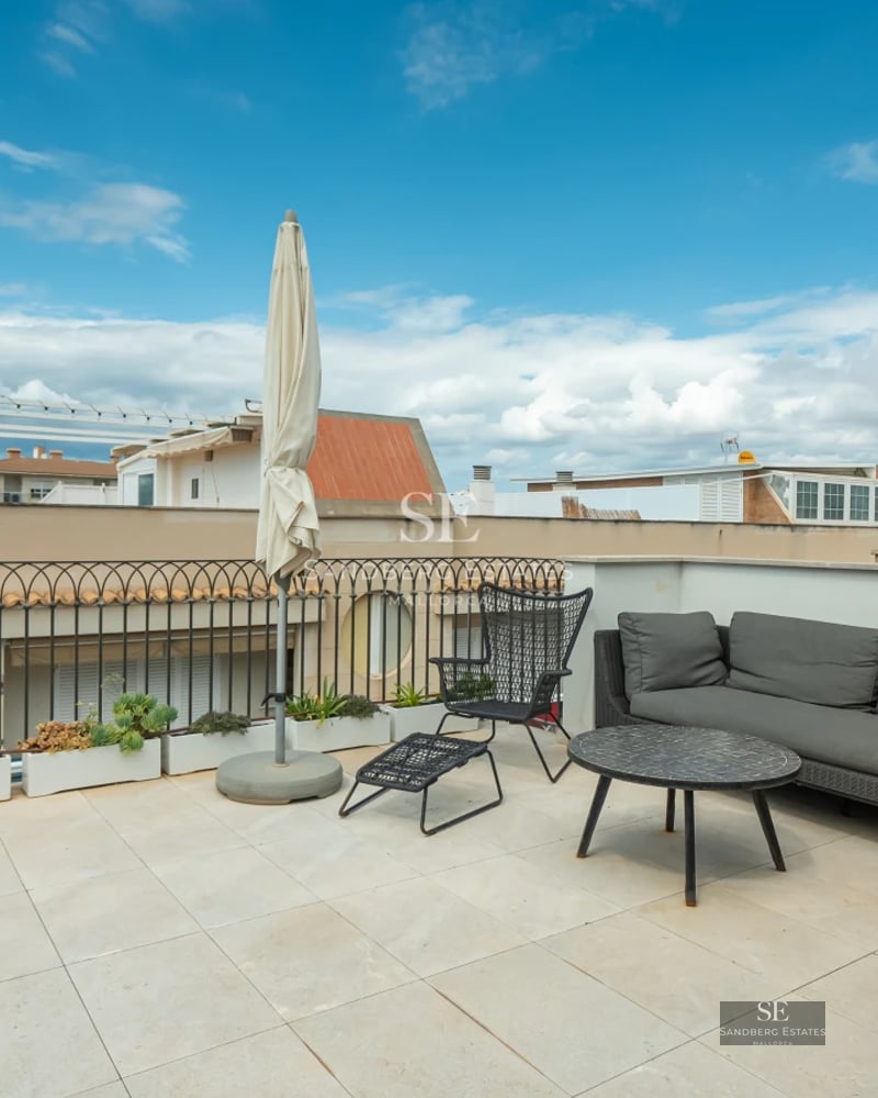 Modern balcony featuring panoramic sea views. Glass railing, light wood flooring, and minimalist furniture. Soft, natural lighting.