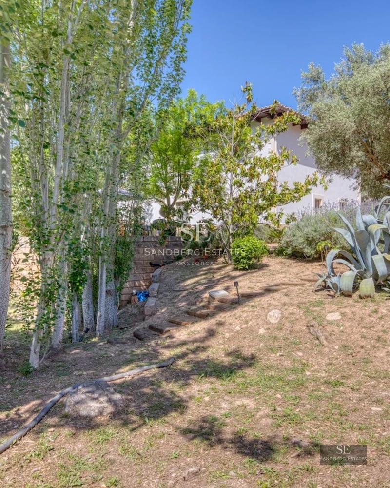 Exterior view of modern villa with infinity pool. Stone facade, large windows, and minimalist design. Blue sky.