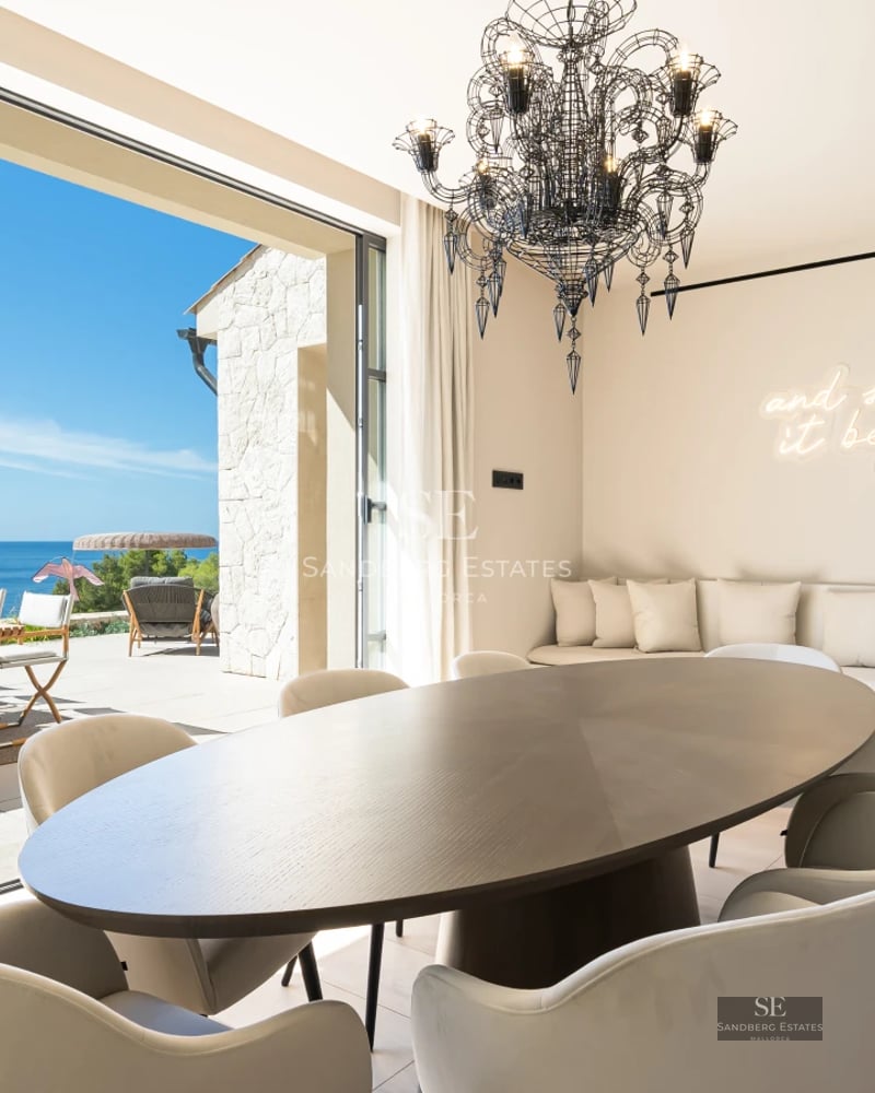 Bright living room with large windows, sea view, stylish sofa, and modern decor. Spacious and luxurious space.