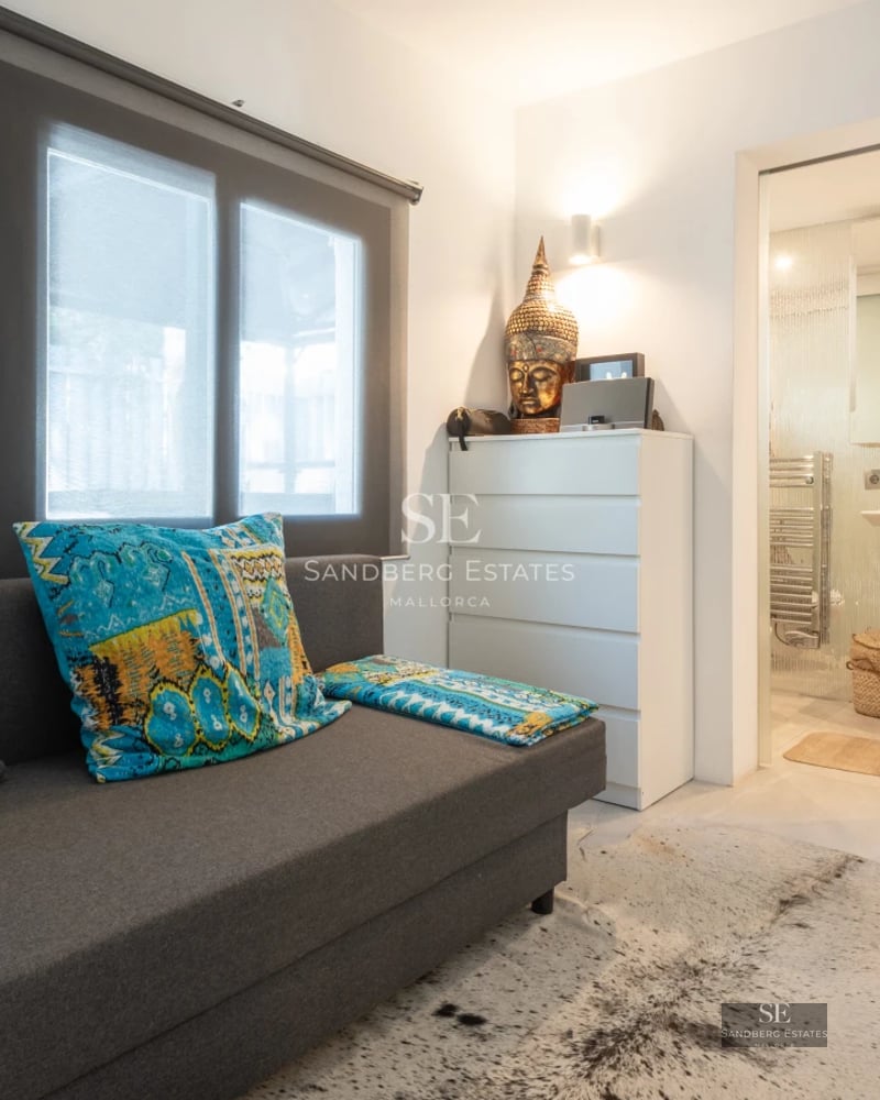 Spacious balcony with panoramic sea views. Glass railing, modern furniture, and minimalist design. Outdoor lamp fixture.