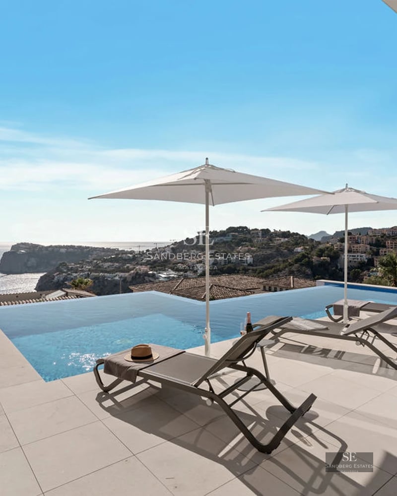 Exterior view of a modern villa with a pool, terrace, and expansive garden. Minimalist architecture with large windows.