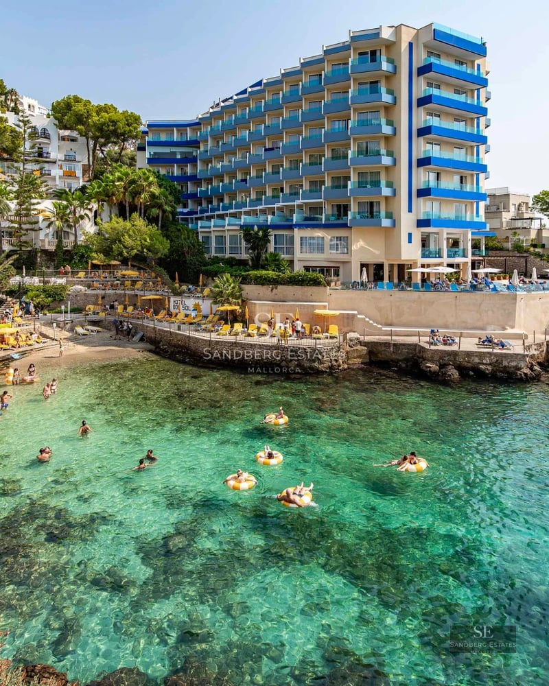 Exterior view of property with pool. Modern architecture, large windows, lush garden and shimmering pool under the sun.