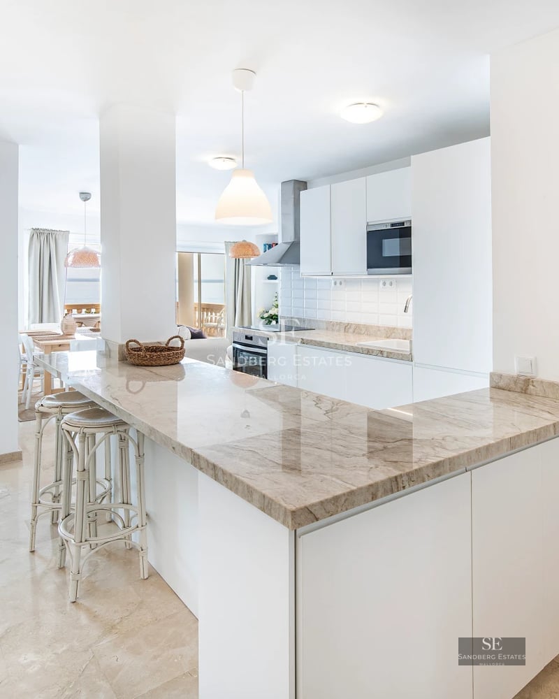 Exterior of a modern villa featuring a pool, large windows, and minimalist design. Lush landscaping and blue sky.