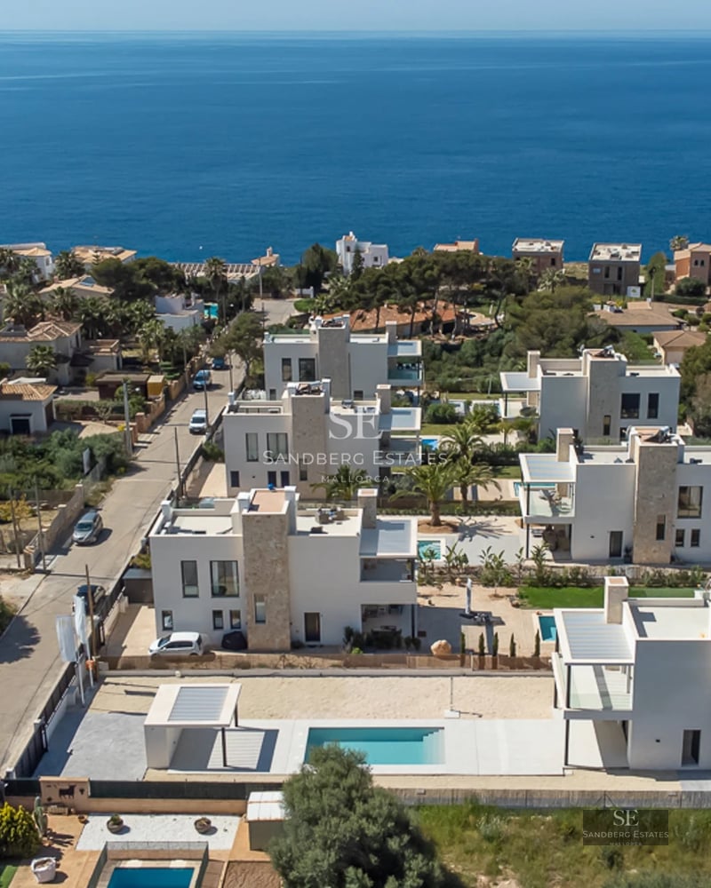 Exterior view of a modern villa with an infinity pool, lush garden, and minimalist architectural design. Soft lighting.