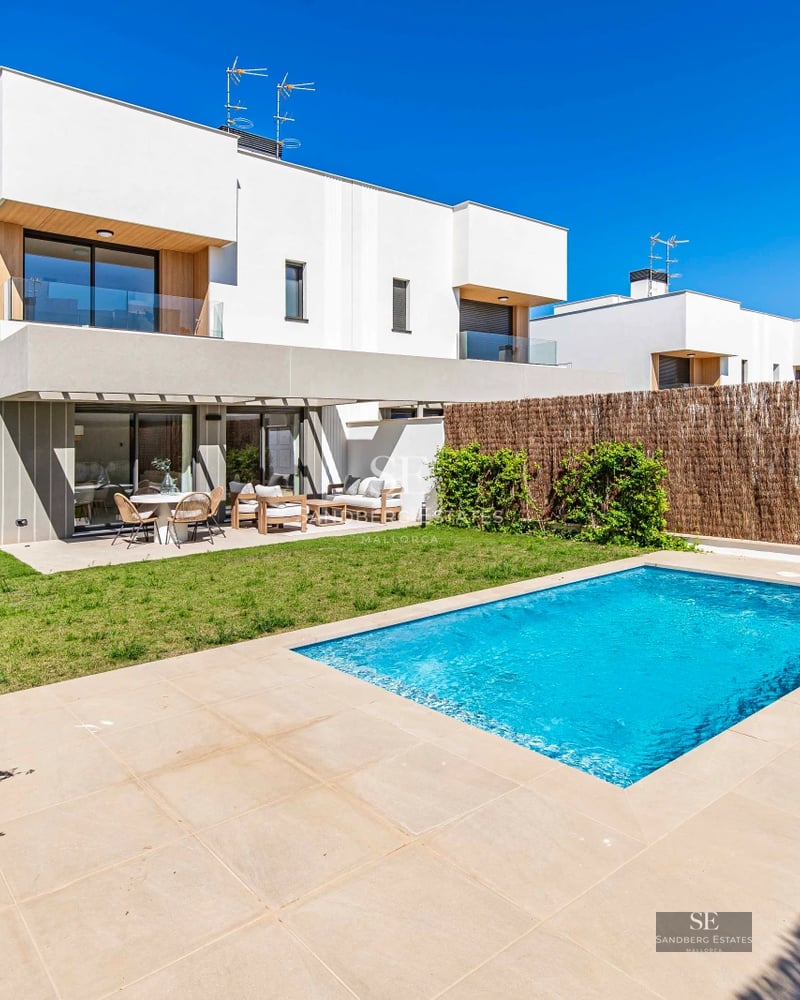 Exterior of a modern villa with an infinity pool, lush garden, and expansive terraces. Minimalist architecture and panoramic views.
