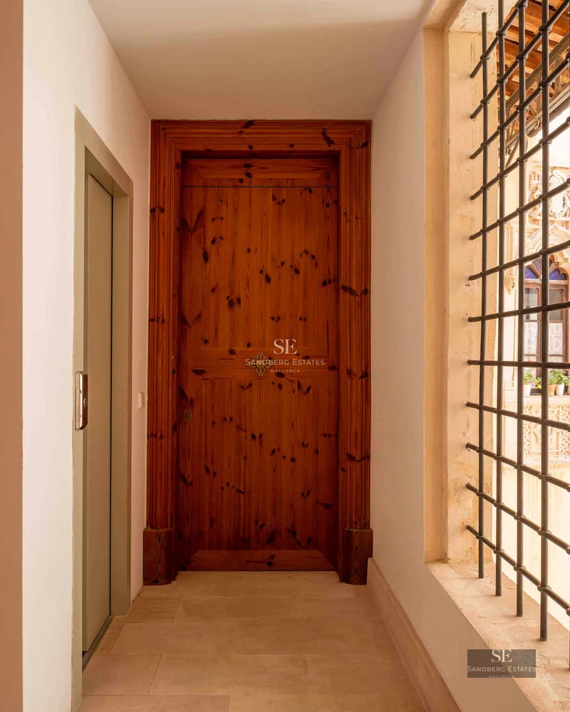 View of a modern infinity pool surrounded by greenery and a minimalist design house in the background.