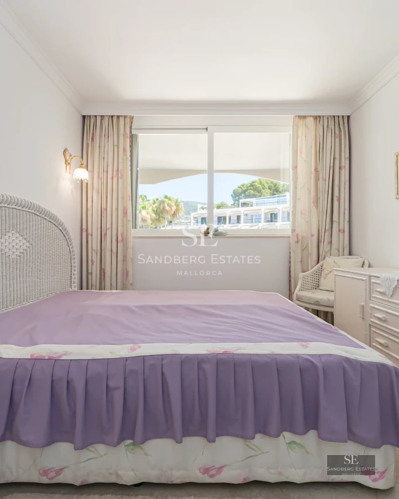 View of a luxurious villa with an infinity pool, manicured garden, and modern architecture. Large windows and covered terrace.