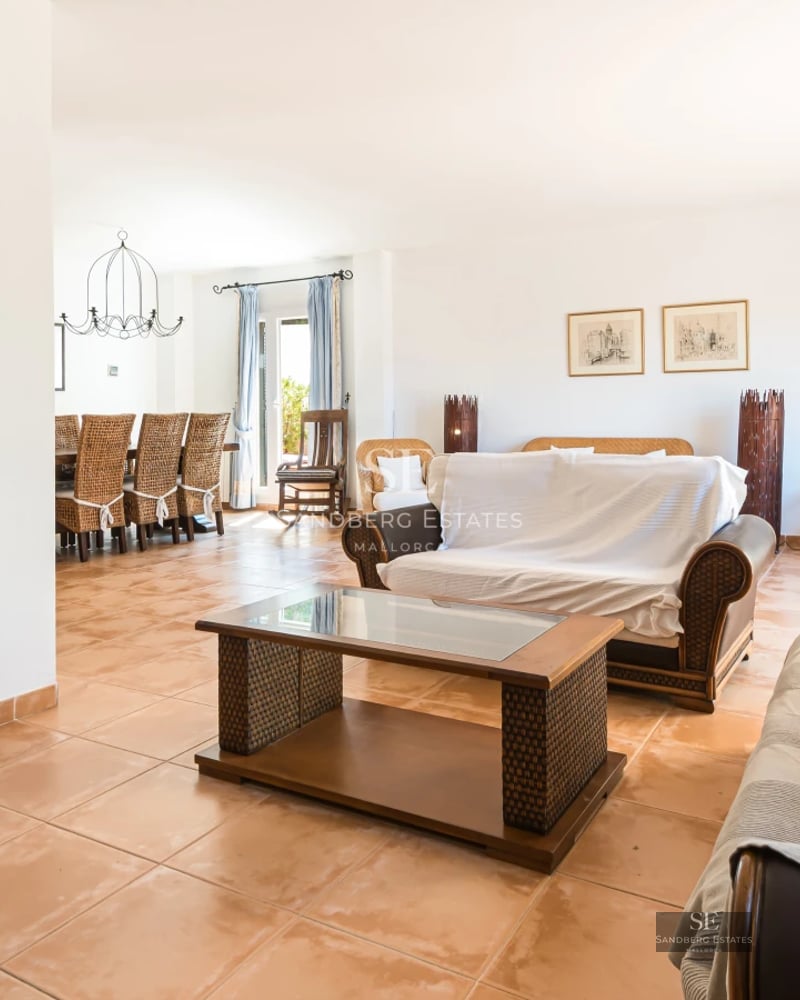 Spacious terrace featuring a pool, sun loungers, and lush greenery. Modern design with large windows. Clear blue sky.